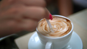 女人在咖啡店用勺子把咖啡混合在一起13秒视频