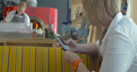 在披萨餐厅有智能手机的女子视频