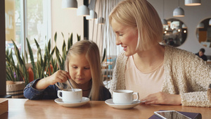 女人把勺子放在咖啡厅的女儿杯杯里9秒视频