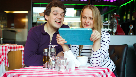 咖啡馆的年轻夫妇在平板电脑上进行视频聊天视频