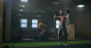 一个人在做繁重的锻炼后会把哑铃扔到健身房的地板上12秒视频