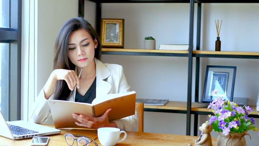 美丽的亚洲女商人坐在电脑笔记本电脑前早上在工作区阅读视频