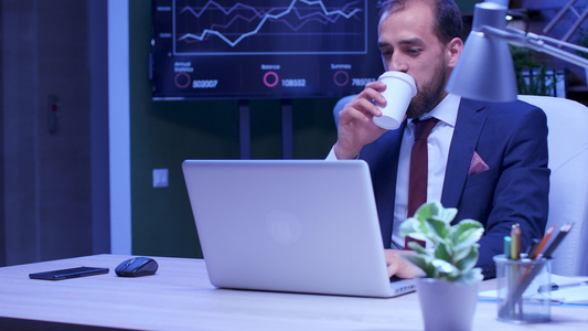 疲累的商人在笔记本电脑工作时喝咖啡视频