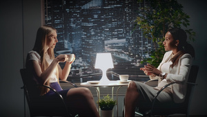 两个年轻商业女青年讲着在桌边喝杯酒的话题30秒视频