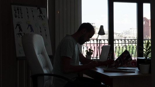 经验丰富的设计师坐在其办公桌办公室从事计算机工作时视频