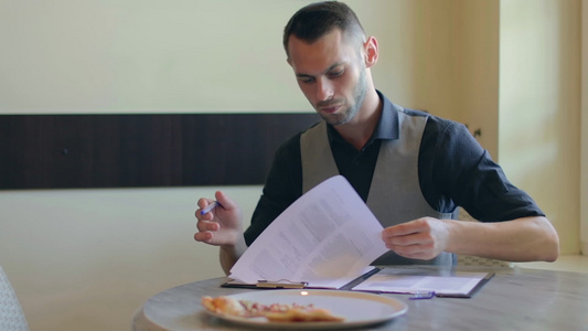 英俊男人在披萨咖啡厅写文件视频