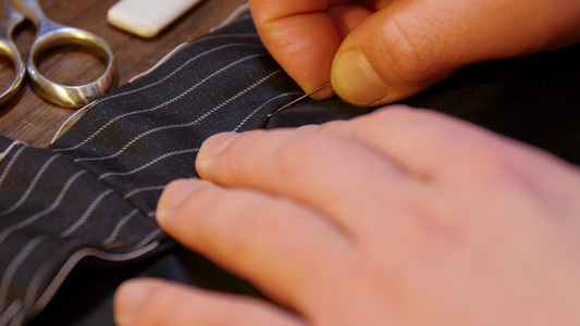 裁缝传统根据古老传统年轻裁缝手缝针线的专业动作视频