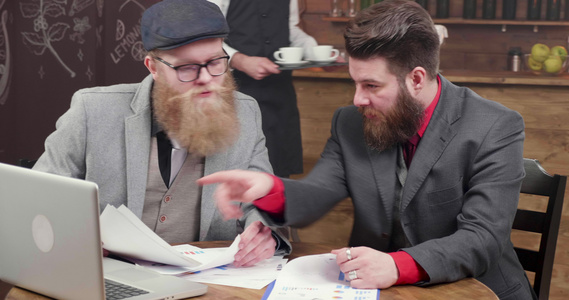 长胡子的英俊大胡子自由职业者去喝咖啡分析新的投资可能性视频
