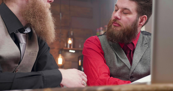 在古董酒吧与两个留胡子商务男性讨论视频