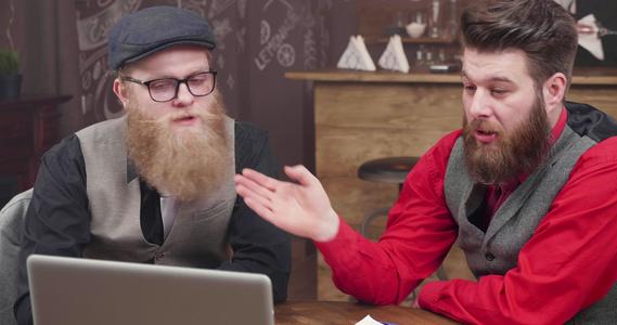 两个家伙在一个古老风格的咖啡店在网上视频电话中向同事视频