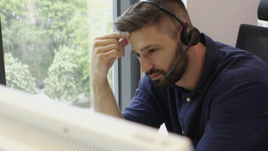 使用耳机在呼叫中心办公室工作的有色胡子有吸引力的商人25秒视频