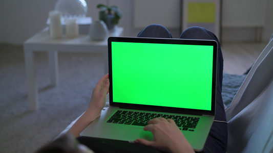 妇女工作或使用笔记本电脑使用绿色屏幕染色体显示视频