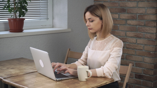 妇女用笔记本电脑和打手咖啡视频