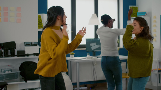 混合种族快乐的女子在创业创意机构办公室欢乐地跳舞视频