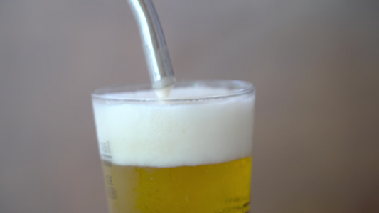 酒保把啤酒倒在玻璃杯里气泡紧闭视频