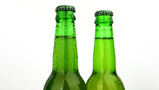 三个绿色啤酒瓶在白色上旋转视频