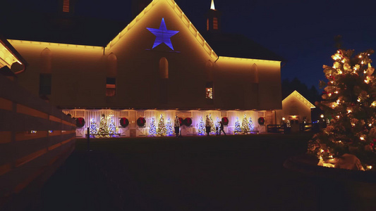 在恢复的古董谷仓举行圣诞照明展览配有树木和花圈视频