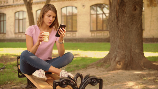 青年女子在大学附近使用智能手机视频