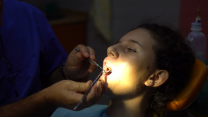 做牙医的小女孩用牙镜检查牙齿17秒视频