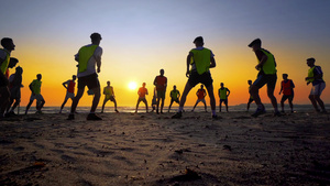 在日落海滩对男孩进行足球队训练25秒视频