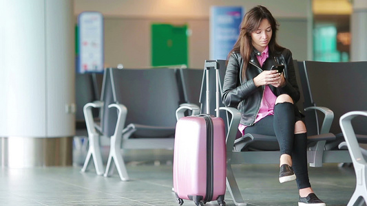 航空公司乘客女孩在机场休息室等待飞行飞机候诊室里拿视频