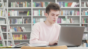 在大学图书馆用笔记本电脑工作的年轻男学生15秒视频