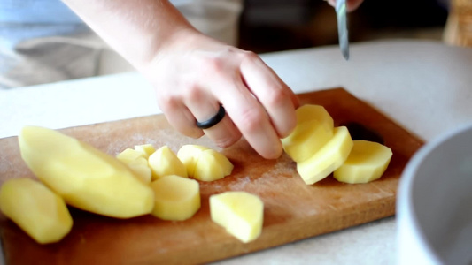 厨师骰子用一把尖利刀在木制剪板上剥土豆用天然产品做视频
