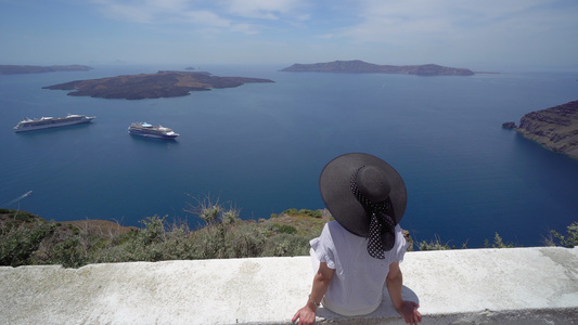 欧洲希腊圣托里尼旅游度假女人看着著名的旅游目的地的视频
