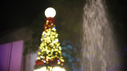 圣诞树在喷泉边闪烁视频