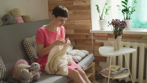 女青年在舒适房间的沙发上织毛衣8秒视频