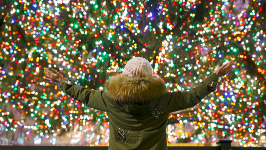 在纽约洛克菲勒圣诞树背景下的快乐女孩洛克菲勒中心美丽视频