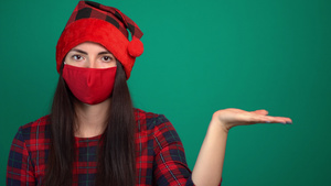 穿着圣塔帽和医疗红色面具的年轻女子拿着看不见的东西17秒视频