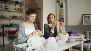 纺织车间坐在桌边的两名制羊毛织物的妇女Knitter7秒视频