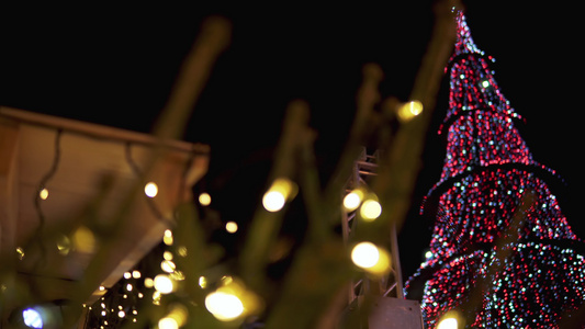 美丽的高高的圣诞树装饰着夜空的花岗岩和多色球视频