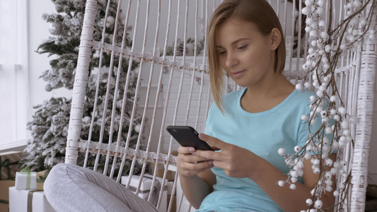 在冬季节日装饰的家里给快乐女孩发短信视频