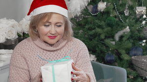 戴着圣达克萨斯帽子的年长快乐女人拿着礼物9秒视频