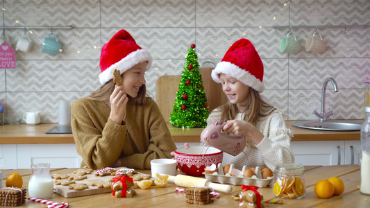 小女孩们在装饰的客厅壁炉里做圣诞姜饼屋视频