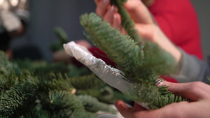 为庆祝圣诞节和新年做准备这个女孩用云杉树枝做一个花环23秒视频