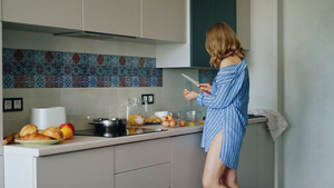 厨房的艺煎蛋卷里穿衬衫的性感女孩准备早餐19秒视频