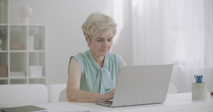年老妇女在家里用笔记本电脑工作13秒视频