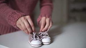 母亲手玩粉色婴儿鞋为编织衣服7秒视频