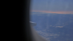 飞机机翼和从飞机窗口高空飞来闪烁的山地景观34秒视频