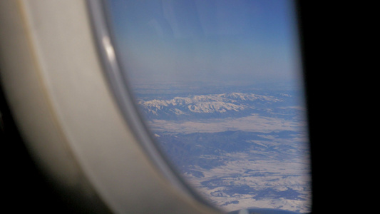 飞机机翼和从飞机窗口高空飞来闪烁的山地景观视频