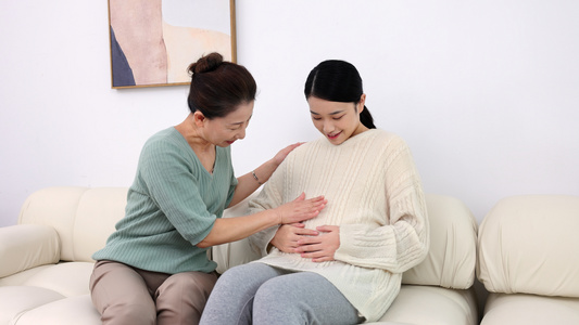 婆婆抚摸着年轻孕妇的肚子视频