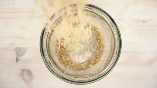 棕稻谷倒在玻璃罐子里简单的基本健康素食概念主题校对视频