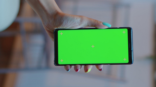 垂直视频家庭主妇持带绿屏的智能手机视频