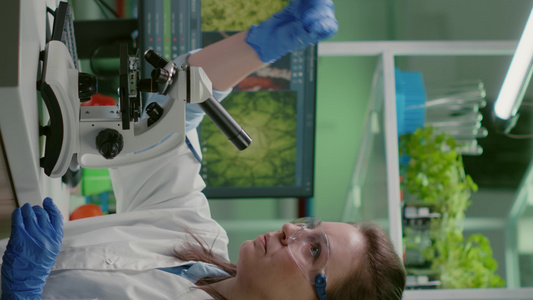 垂直视频生物学家利用显微镜观察试样在使用显微镜进行【竖版】视频