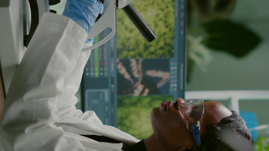 垂直视频在显微镜下观察试样的生物学家妇女视频