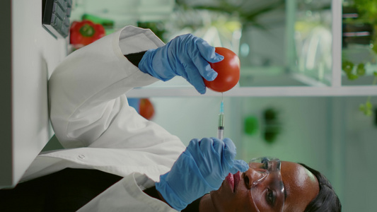垂直视频非洲生物化学家配有医疗手套用杀虫剂注射有机视频