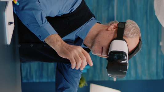 垂直视频退休人员在客厅使用Vr头盔体验虚拟现实的退休视频